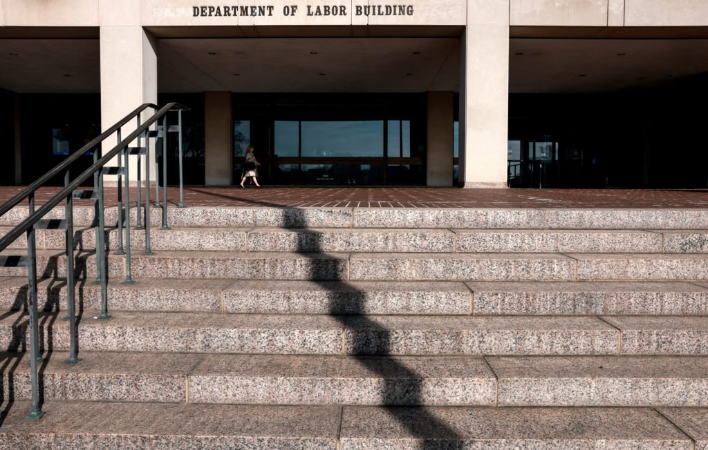 A woman walks into the U.S. Department of Labor, which published its weekly initial jobless claims report, in Washington