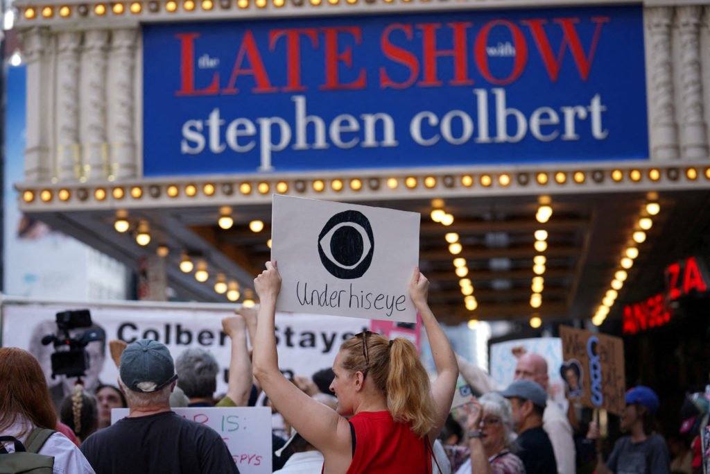 FILE PHOTO: People protest after CBS/Paramount announced the cancellation of The Late Show with Stephen Colbert in New York