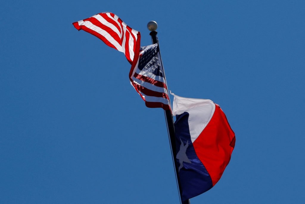 FILE PHOTO: The U.S flag and the Texas State flag fly over the Texas State Capitol in Austin