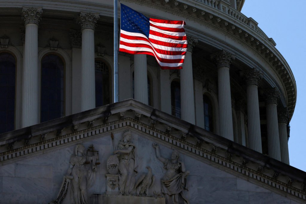 The U.S. flag flies in front of the dome atop the U.S. Capitol in Washington